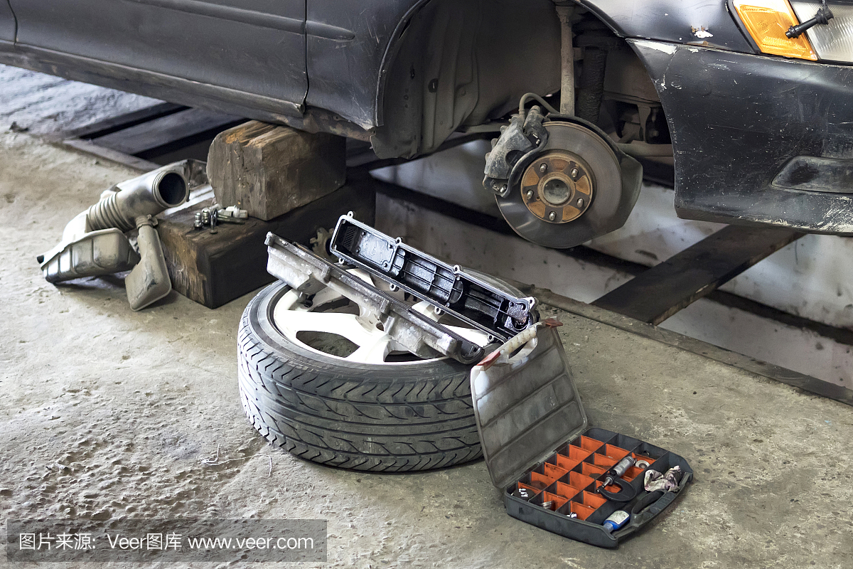 汽车制动部件在车库,汽车制动盘没有车轮特写。在家庭车库更换一辆旧车的轮子